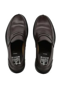 Mocassini in pelle marrone con design slip-on, punta rotonda, cuciture decorative e suola testurizzata. L'interno presenta una fodera imbottita.