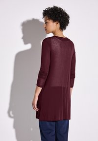 Bordeaux lange mouw tuniek met een ronde halslijn, met een semi-doorzichtige textuur en aansluitende mouwen, gecombineerd met een relaxed-fit marineblauwe broek.