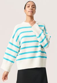 Strickpullover in Creme mit blauen horizontalen Streifen. Hat weite Ärmel und einen gerippten Saum. Weiche Textur, lässige Passform und runder Ausschnitt.