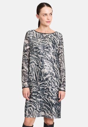 Paillettenkleid mit langen Ärmeln, featuring eines schwarz-silbernen Zebra-Musters, Boot-Ausschnitt und lockerer Passform. Die Textur wirkt glänzend und reflektierend.