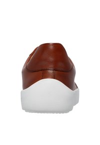 Rjavi usnjeni športni copat z zaobljenim petnim delom, belo gumijasto podplatom in čistimi linijami. Minimalni šivi in gladka tekstura. Zadnji pogled.