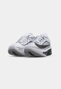 Hvite løpesko med mesh-overdel, svarte detaljer og en teksturert såle. Har snøring og "ZOOM FLY" merke på tungen.