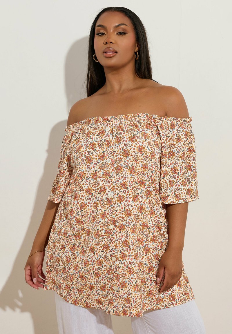 Top floreale scollato in crema con motivi arancioni e blu. Maniche corte, vestibilità larga e tessuto leggero.