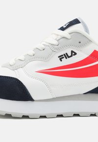 Hvite lær sneakers med marineblå semsket skinn-detaljer, et rødt swoosh-design og hvite snørebånd. Har en strukturert såle med mønstre for godt grep.
