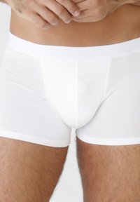Boxer briefs bianchi elasticizzati con una texture liscia, caratterizzati da un anteriore strutturato e una cintura elastica a contrasto. Design laterale senza cuciture.