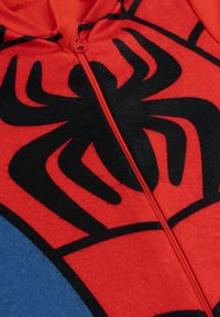 Felpa rossa con zip e logo di ragno nero sul fronte, con una texture morbida e accenti blu a contrasto sui lati.