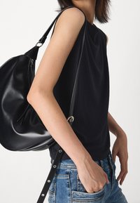 Czarny prążkowany top bez rękawów z wysokim dekoltem. Noszony z czarną skórzaną torbą hobo z paskiem na ramię i detalem z zamkiem błyskawicznym.