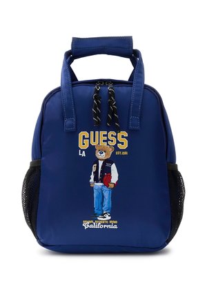 Sac à dos bleu avec double poignée, poches latérales en filet noir, et un ours portant une veste universitaire tenant un ballon de basket devant.