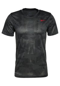Černé sportovní tričko s krátkým rukávem, které má vzor včelí plástve, technologii Dri-FIT a červené logo Nike swoosh na levé části hrudi.