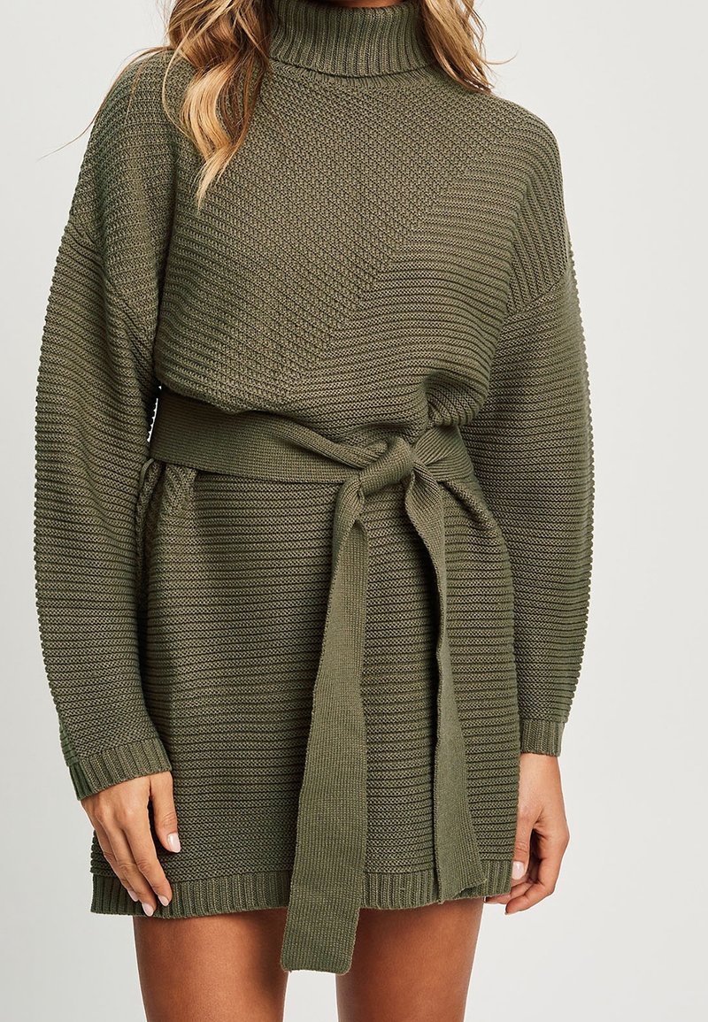Robe-pull tricotée vert olive avec motifs texturés, manches longues, col montant et ceinture nouée à la taille.