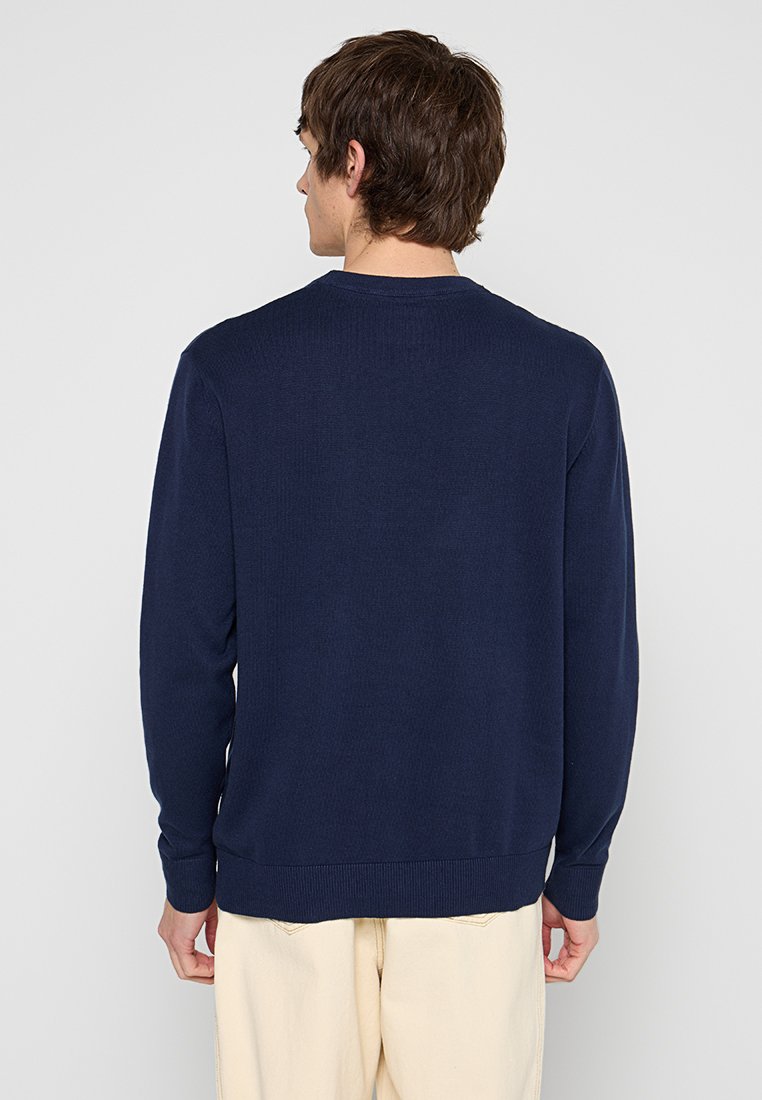 Maglione a maglia blu navy con maniche lunghe, polsini e orlo a coste, design a girocollo, texture liscia e senza motivi o dettagli visibili.