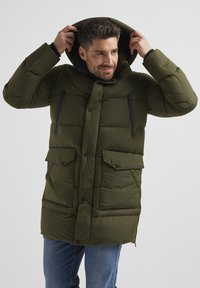 Grüne Pufferjacke mit Kapuze, ausgestattet mit einem Frontreißverschluss, Druckknöpfen, zwei großen Klappentaschen und zwei mit Reißverschluss versehenen Brusttaschen.