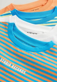 Trois T-shirts en orange, blanc et bleu, avec des rayures horizontales. Le T-shirt orange présente des rayures bleues, tandis que le T-shirt blanc a un motif bleu et jaune.