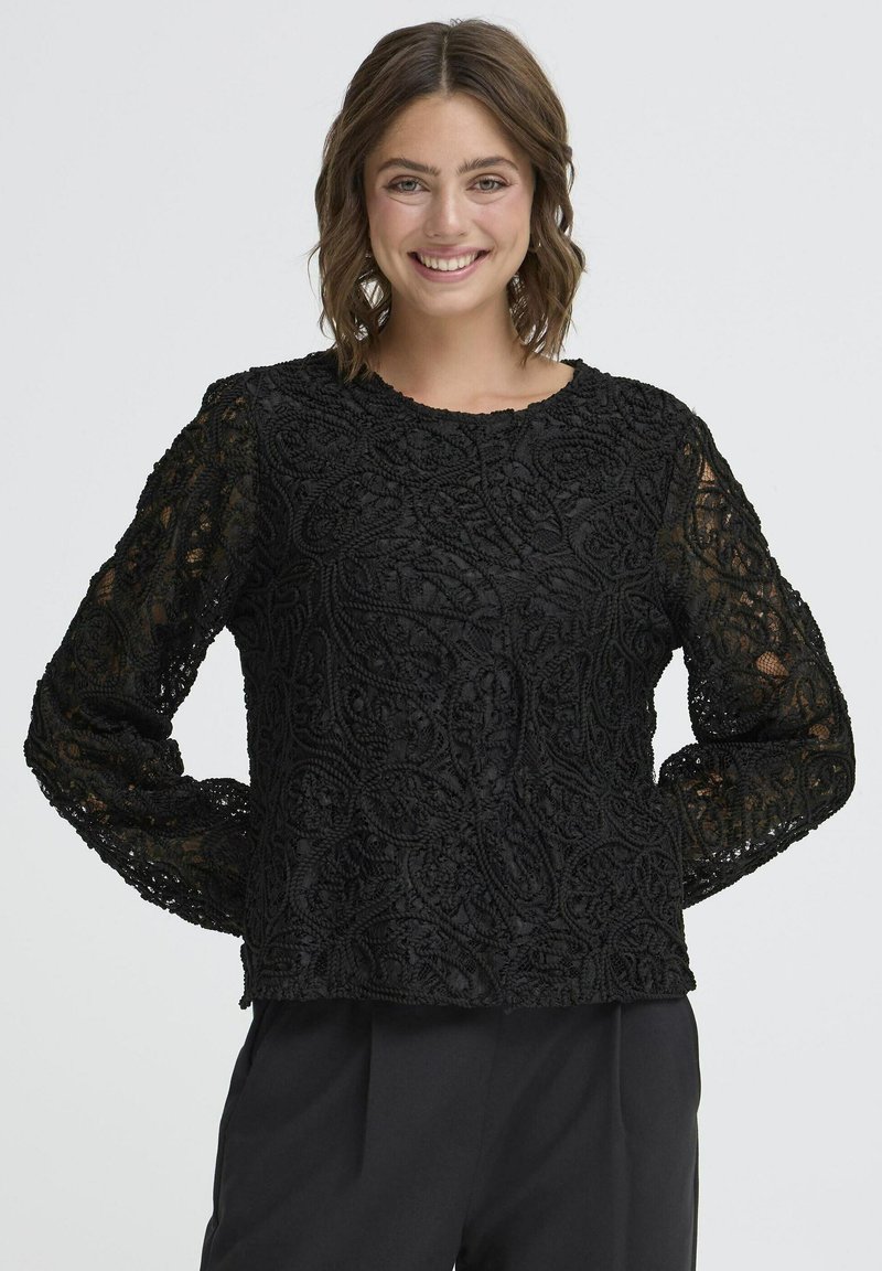 Crni dolgi rukav majica s složenim vezenim uzorcima, okruglim izrezom i prozirnim čipkastim rukavima. Materijal izgleda teksturirano i slojevito.