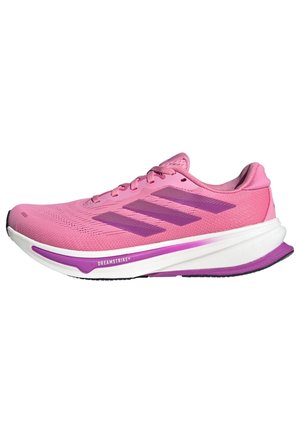 Różowy but do biegania z fioletowymi paskami Adidas, biała i fioletowa amortyzowana podeszwa z napisem "Dreamstrike+", widok z boku na białym tle.