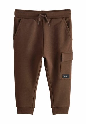 Pantalon de jogging marron pour enfants avec ceinture élastique, cordon, poches latérales, chevilles côtelées et une poche cargo avec un écusson sur la jambe droite.