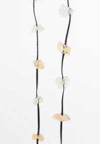 Černý provázkový náhrdelník s nepravidelně tvarovanými krystaly v průhledných a světlých jantarových tónech, uspořádanými alternativně podél délky.