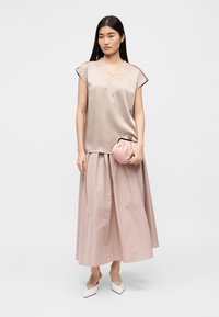 Top ușor de culoare taupe sidefată, cu bordură din dantelă, combinat cu o fustă roz-prafuită vaporoasă, până la genunchi. Țin o geantă plic rotundă, roz pal. Pantofi albi, cu vârf ascuțit.