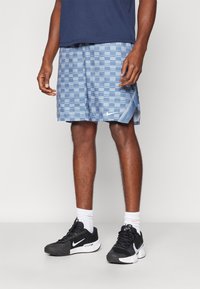 Sinised ruudulise musteriga Nike lühikesed püksid, külgsirmid, koos mustade Nike jalatsite ja valgete sokkidega. Tavaline lõige, kergest materjalist.
