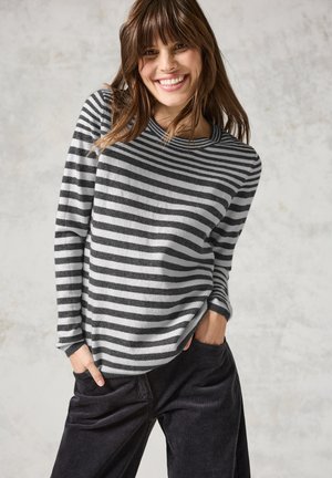 Grijze en witte gestreepte sweater, ronde halslijn, lange mouwen, gemaakt van zacht materiaal. Gecombineerd met donkere korduroypantalon.