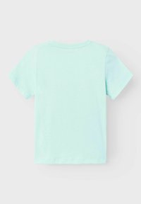 Camiseta de manga corta verde claro con cuello redondo clásico, hecha de tela de algodón suave. Textura lisa y color uniforme, sin patrones ni detalles.