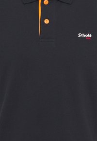 Granatowa koszulka polo wykonana z teksturowanej tkaniny, z pomarańczowym zapięciem, trzema guzikami oraz białym haftowanym logo 'Schott NYC' na klatce piersiowej.