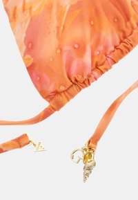 Silk bag with an orange floral pattern, gathered top, and gold-tone hardware featuring a shell charm and triangular detail on the strap.