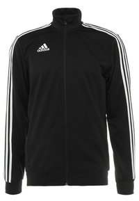 Svart zip-up jacka med hög krage, vit tre-stripsdesign på ärmarna, texturerad tyg och broderad logotyp på bröstet.