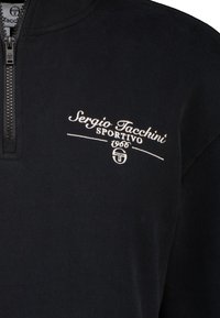 Pullover blu scuro con collo a quarto di zip, caratterizzato da un logo ricamato bianco con la scritta "Sergio Tacchini Sportivo 1966" sul petto.