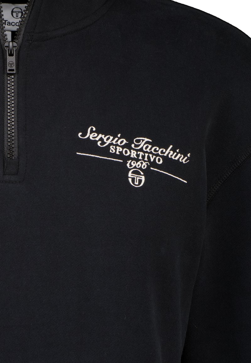 Ciemnoniebieski sweter z zamkiem błyskawicznym na ćwierć, z białym haftowanym napisem "Sergio Tacchini Sportivo 1966" na piersi.