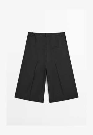 Zwarte shorts met brede pijpen gemaakt van een lichtgewicht stof. Voorzien van een gestructureerde tailleband en een enkele achterzak, met een gladde textuur en een strak ontwerp.