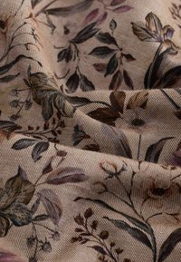Tessuto con motivo floreale caratterizzato da uno sfondo beige con motivi botanici verdi, marroni e viola, testurizzato con sottili strisce diagonali.