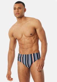 Marinblå och orange randiga baddräkter med en tajt passform, med en mjuk textur och elastisk midja.