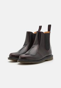 Brune lær Chelsea støvler med elastiske sidestykker, syede detaljer og trækflapper. Gummisål, strømlinet design, poleret finish.
