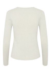 Vaalea beige, pitkähihainen kammattu neulepaita, jossa on pyöreä kaula-aukko. Materiaalissa on hieno kiilto ja teksturoitu pinta. Ei näkyviä varusteita tai kuvioita.