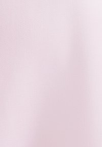 Tessuto di un delicato rosa chiaro con un motivo a spina di pesce diagonale e sfumature sottili che creano profondità.