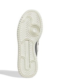 Suola di sneaker in gomma bianca con motivi antiscivolo, caratterizzata da un design circolare al centro e dal logo "adidas" in rilievo.