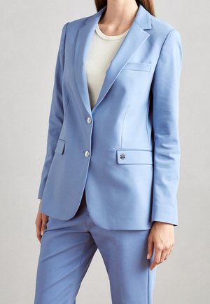 Veste de costume ajustée bleu clair avec revers cranté, fermeture à deux boutons et poches latérales. Tissu lisse avec un design propre et structuré.