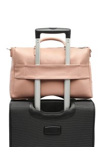 Ružičasta kožna torba sigurno postavljena na crni teksturirani kovčeg s teleskopskom ručkom, koji ima gornju ručku za nošenje i zatvaranje na zip.