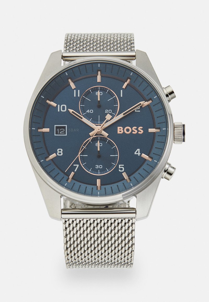 Reloj de acero inoxidable plateado con esfera azul, acentos en oro rosa, características de cronógrafo y pulsera de malla. Incluye visualización de la fecha.