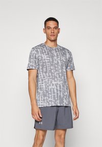 Grå tie-dye t-skjorte med korte ermer, rund hals og myk tekstur, kombinert med grå treningshorts med logoakkent.