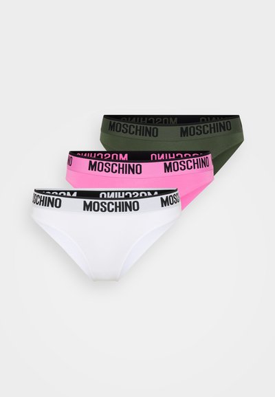 Tri pari ženskih hlačk: bele, roza in olivne zelene. Vsake imajo črn pas z napisom "MOSCHINO" v roza črkah.