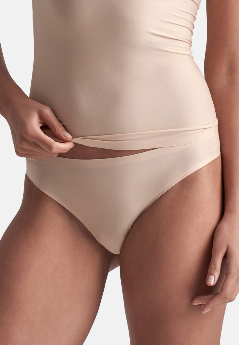 Mutande nude senza cuciture realizzate in tessuto liscio e elastico. Presentano una sottile cintura elastica e un design a vita bassa. Adatte per un uso quotidiano.