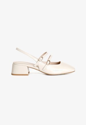 Slingback con tacco in morbida pelle color crema, dotate di due sottili cinghie con fibbie in metallo, punta quadrata e tacco basso a blocco.