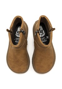 Botas de tobillo de ante marrón con puntera redonda, cremalleras laterales y un acabado texturizado. En el interior cuentan con una plantilla negra con un diseño de calavera.