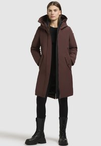 Brun isoleret parka med hætte, to frontlommer og lynlås. Den har en glat tekstur og en moderne, forlænget pasform.