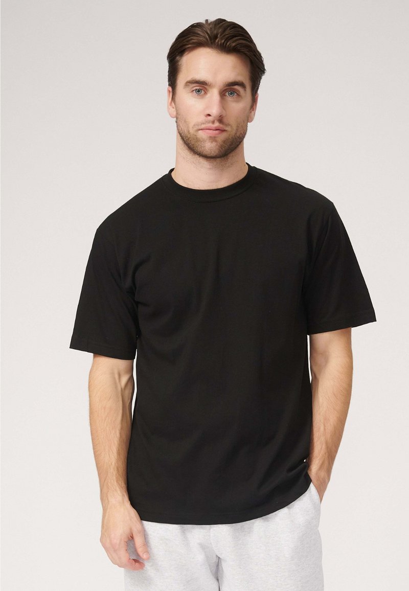Sort bomulds T-shirt med rund halsudskæring, korte ærmer og en afslappet pasform, med en glat tekstur og uden synlige mønstre eller detaljer.