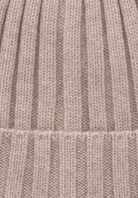 Beżowa dziana czapka z pionowym prążkowanym wzorem, z naprzemiennie ułożonymi włóknami i podwójnym brzegiem u dołu.