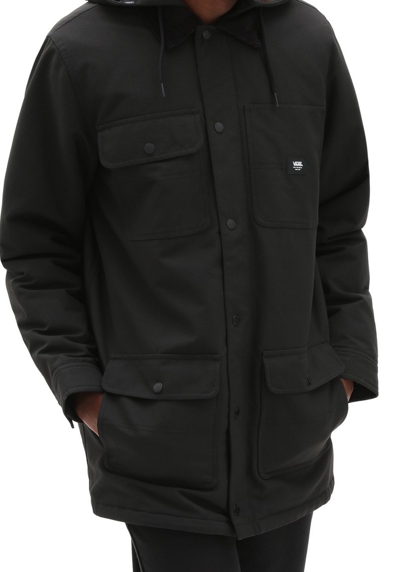 Giacca nera isolata con cappuccio, dotata di due tasche sul petto e due tasche inferiori, realizzata in tessuto resistente con chiusure a bottone.