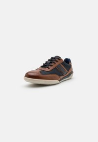 Brown leather and navy mesh sneaker with black laces, cream rubber sole, and diagonal accent stripes on the sides. Rounded toe design.